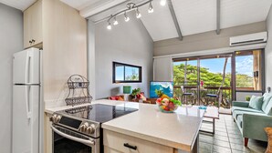 A modern kitchen with a built-in oven, a refrigerator, and a dining area with a table and chairs.