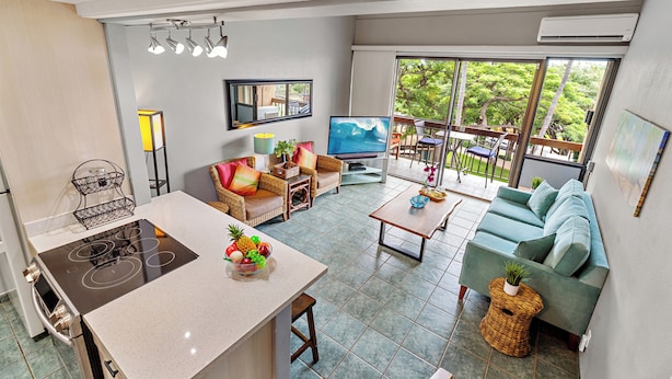 A modern living room with a kitchen area, a sofa set, and a dining area.