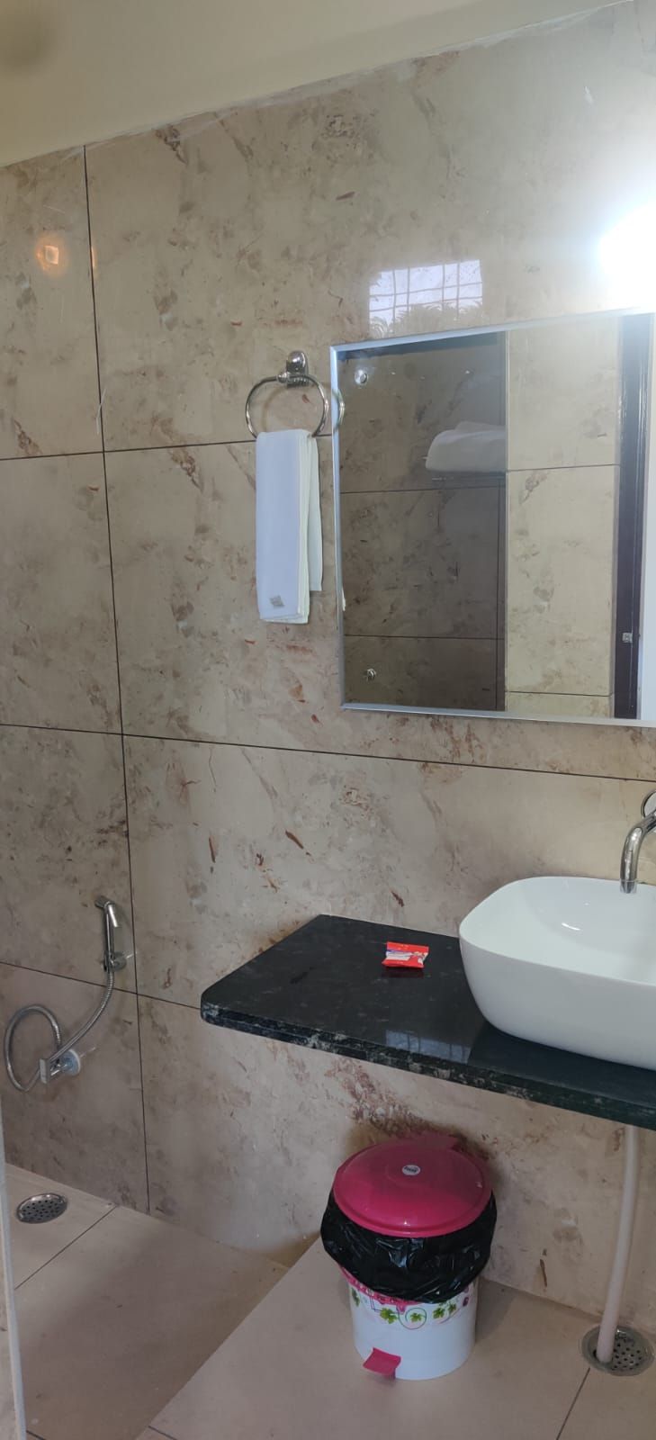 A bathroom with a white sink, a mirror, and a towel rack.