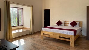 Una camera da letto con un letto in legno, una finestra con tende, una ventola a soffitto e una scrivania.