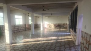 Un couloir spacieux doté d’un sol à motifs, de murs blancs et de ventilateurs de plafond.