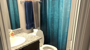A bathroom with a toilet, sink, and a shower curtain.