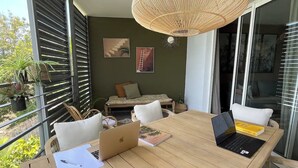 Una mesa de madera con dos computadoras portátiles, un cuaderno y un bolígrafo.