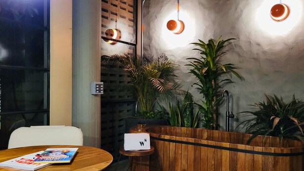 A cozy restaurant interior with wooden furniture, a round table with a magazine, and potted plants. - w Dazzling Loft w Majestic Deco in Poblado (Medellín)