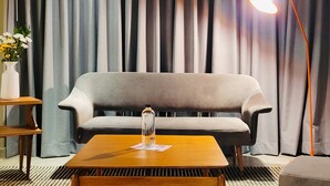 A modern living room with a grey sofa, a wooden coffee table, a floor lamp, and a vase with flowers. - w Dazzling Loft w Majestic Deco in Poblado (Medellín)