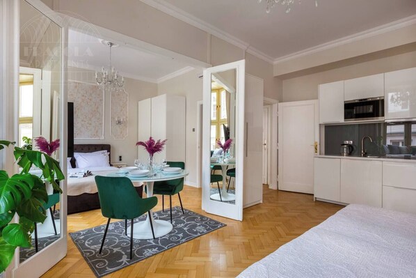 A modern apartment with a dining area, kitchen, and bedroom.