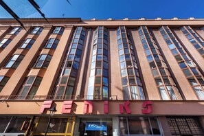 Un edificio con el letrero 'FENIKS' en la planta baja, con grandes ventanales y un estilo arquitectónico moderno.