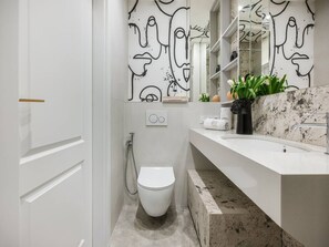 Un baño moderno con inodoro, lavabo y ducha.