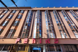 Ein Gebäude mit dem Schriftzug 'FENIKS' im Erdgeschoss, ausgestattet mit großen Fenstern und einer modernen Architektur.