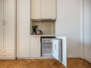 Eine Küche mit weißen Schränken, einem eingebauten Ofen und einem Kühlschrank.