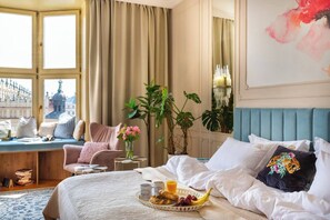 Une chambre d’hôtel avec un lit, un plateau de petit-déjeuner, une fenêtre avec des rideaux et une vue sur un immeuble.