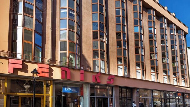 A multi-story building with a prominent 'FEDINE' sign on the ground floor, featuring a glass storefront and a visible entrance.