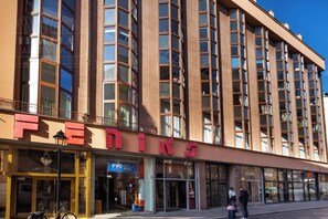 A multi-story building with a prominent 'FEDINE' sign on the ground floor, featuring a glass storefront and a visible entrance.