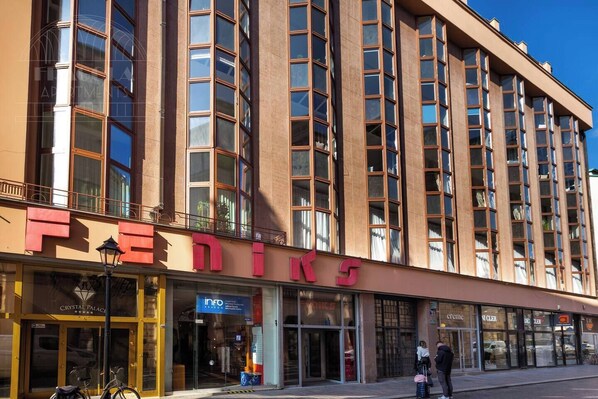 A multi-story building with a prominent 'FEDINE' sign on the ground floor, featuring a glass storefront and a visible entrance.