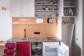 Uma cozinha compacta com pia, lava-louças e armários.