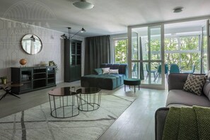A modern living room with a sofa, a coffee table, a cabinet, and a large window.