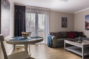 A modern living room with a round table, a sofa, and a coffee table.