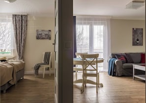 Una habitación con cama, una silla, una mesa y un sofá.