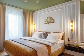 A large bed with a gold headboard, white bedding, and decorative pillows. - Apartment Ivory Dream (Kraków – Old Town)