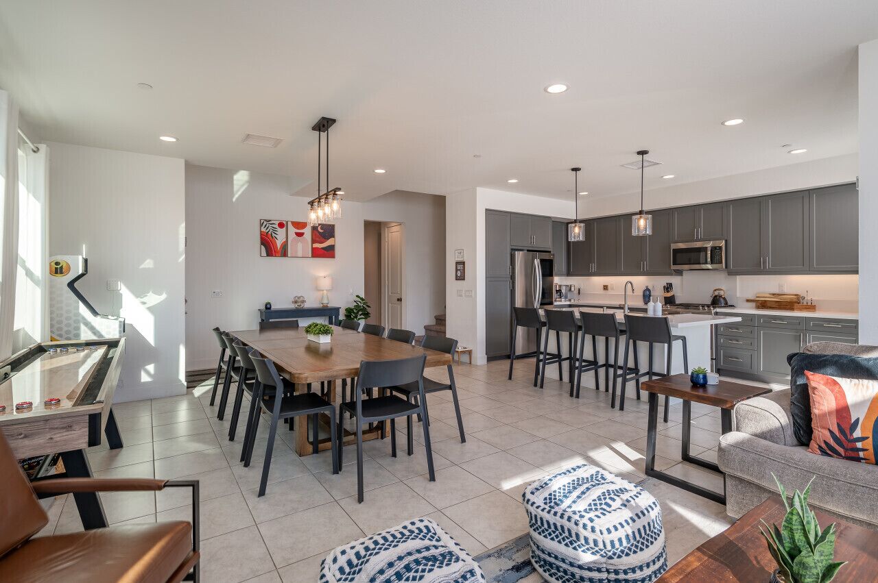 A modern kitchen with grey cabinets, a stainless steel refrigerator, and a built-in microwave.