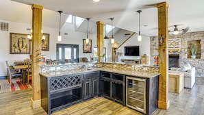 A spacious kitchen with a large island, wooden beams, and pendant lighting. - Hot Tub + Fire Pit: Possum Kingdom Lake Retreat! (Caddo)