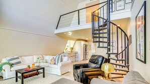 A spacious living area with a high ceiling, a staircase, and a kitchen in the background. - Lakefront Home w/ Private Dock in Graford! (Graford)