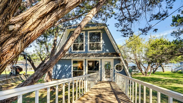 A house with a white porch and a pathway leading to the entrance. - Lakefront Home w/ Private Dock in Graford! (Graford)