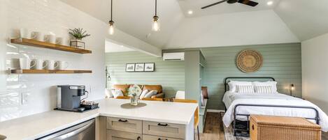 A modern kitchen with a coffee machine, wooden cabinets, and a dining area with a table and chairs.