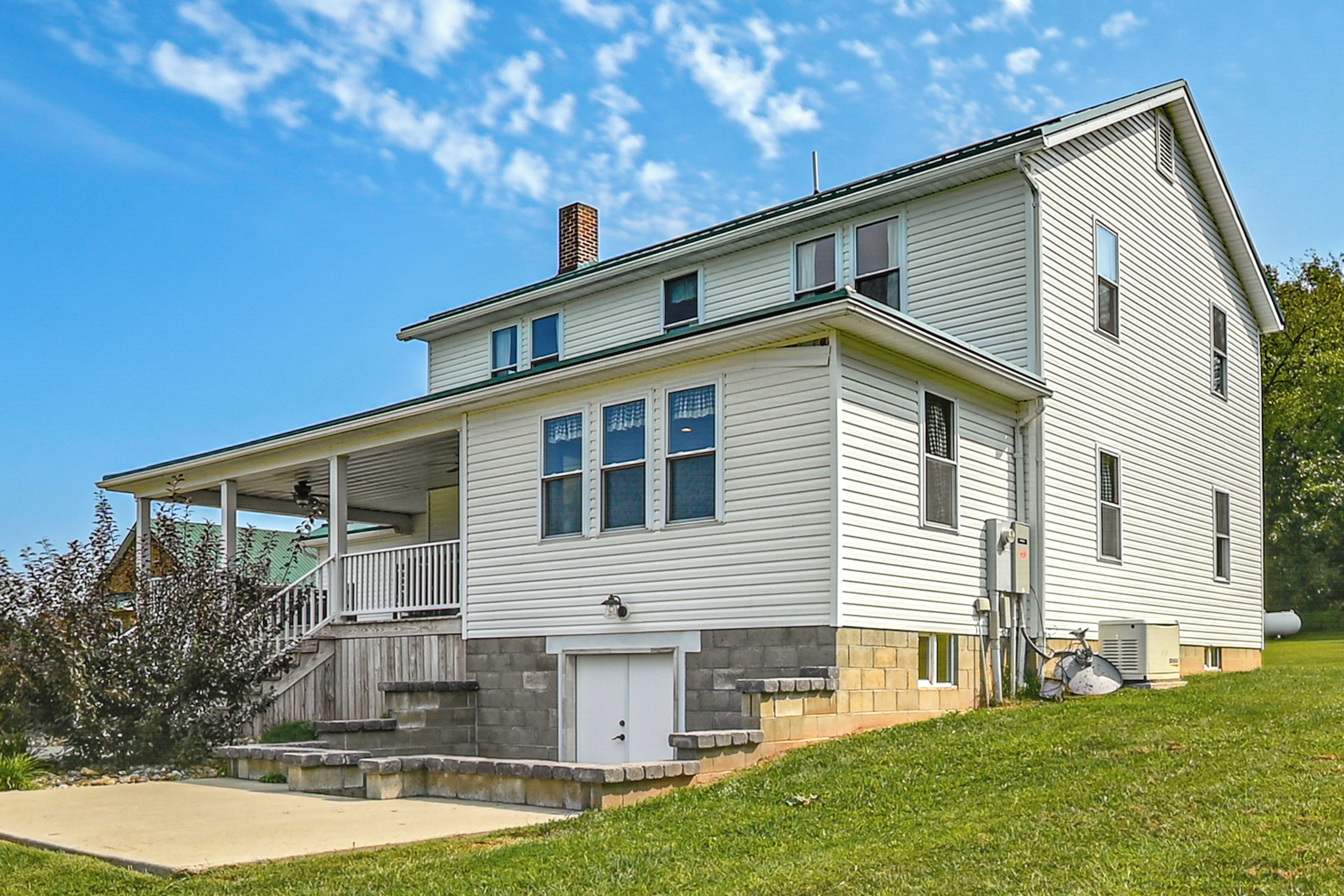 A two-story house with a covered porch, a garage, and a small front yard.