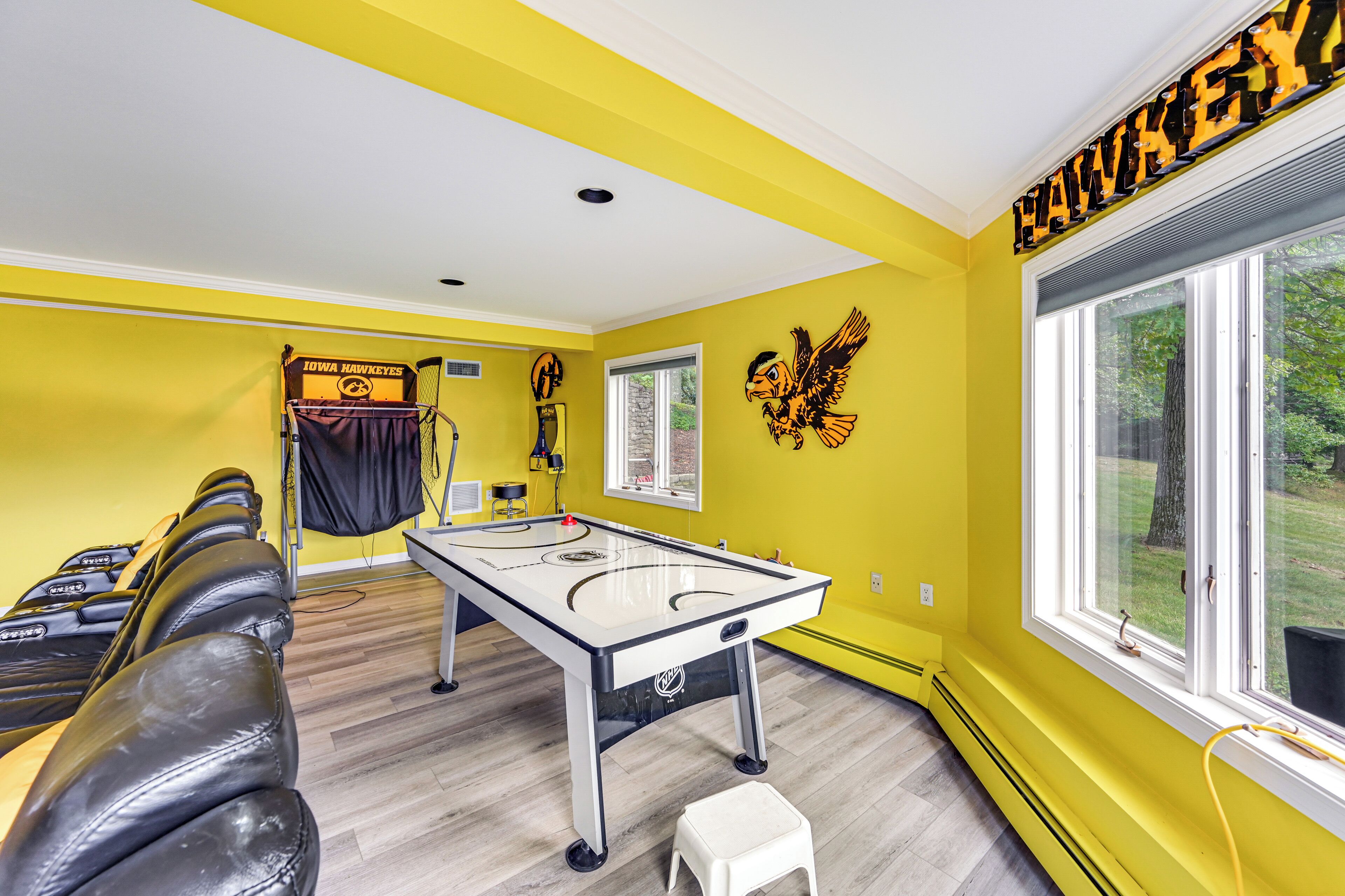 A room with a pool table, a massage chair, and a large window.