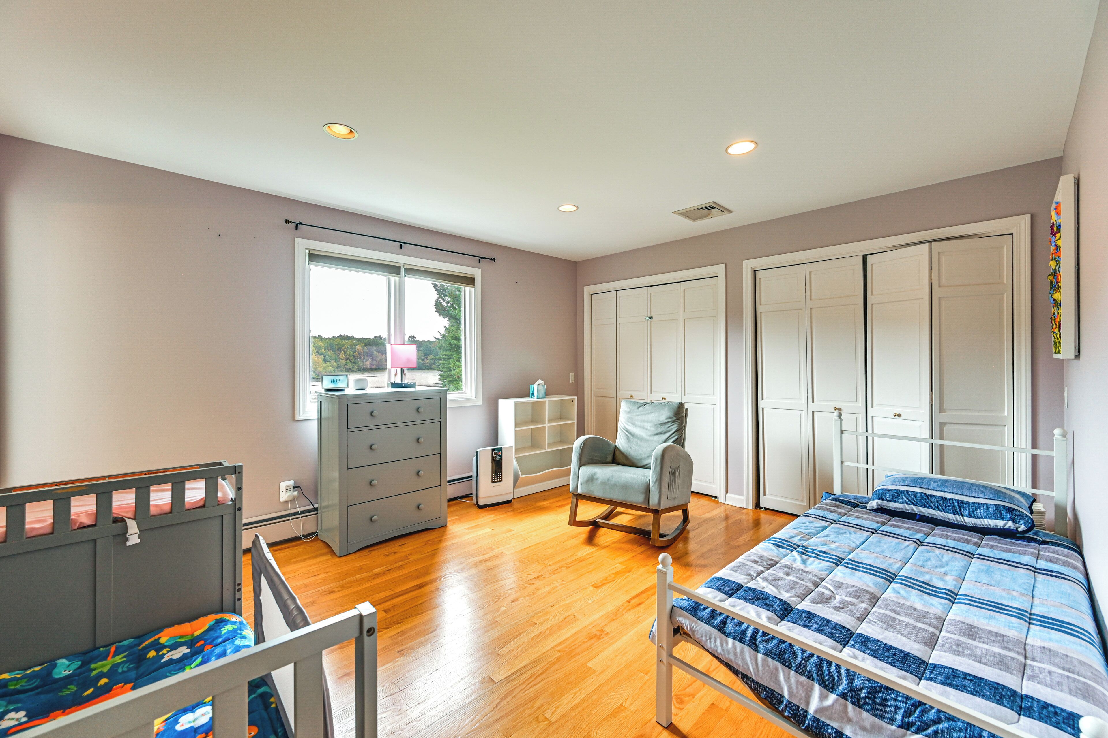 A bedroom with a bed, dresser, chair, and wardrobe.