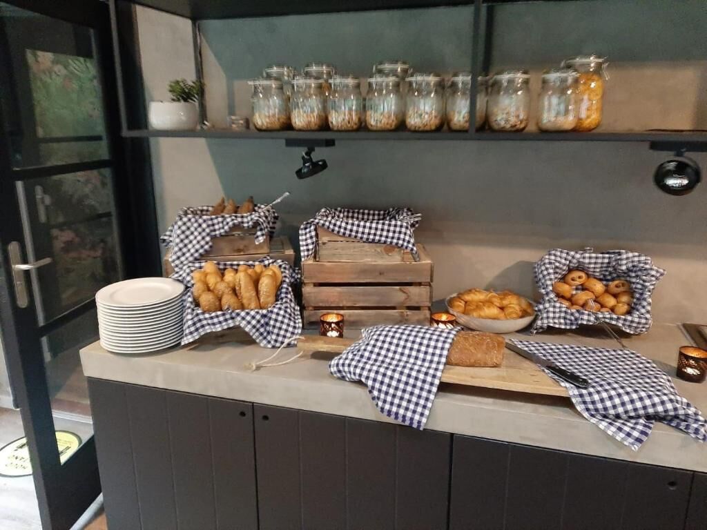 Ein reichhaltiges Buffet mit verschiedenen Speisen, darunter Gebäck und Brot, präsentiert auf einer Theke mit karierten Tischdecken.