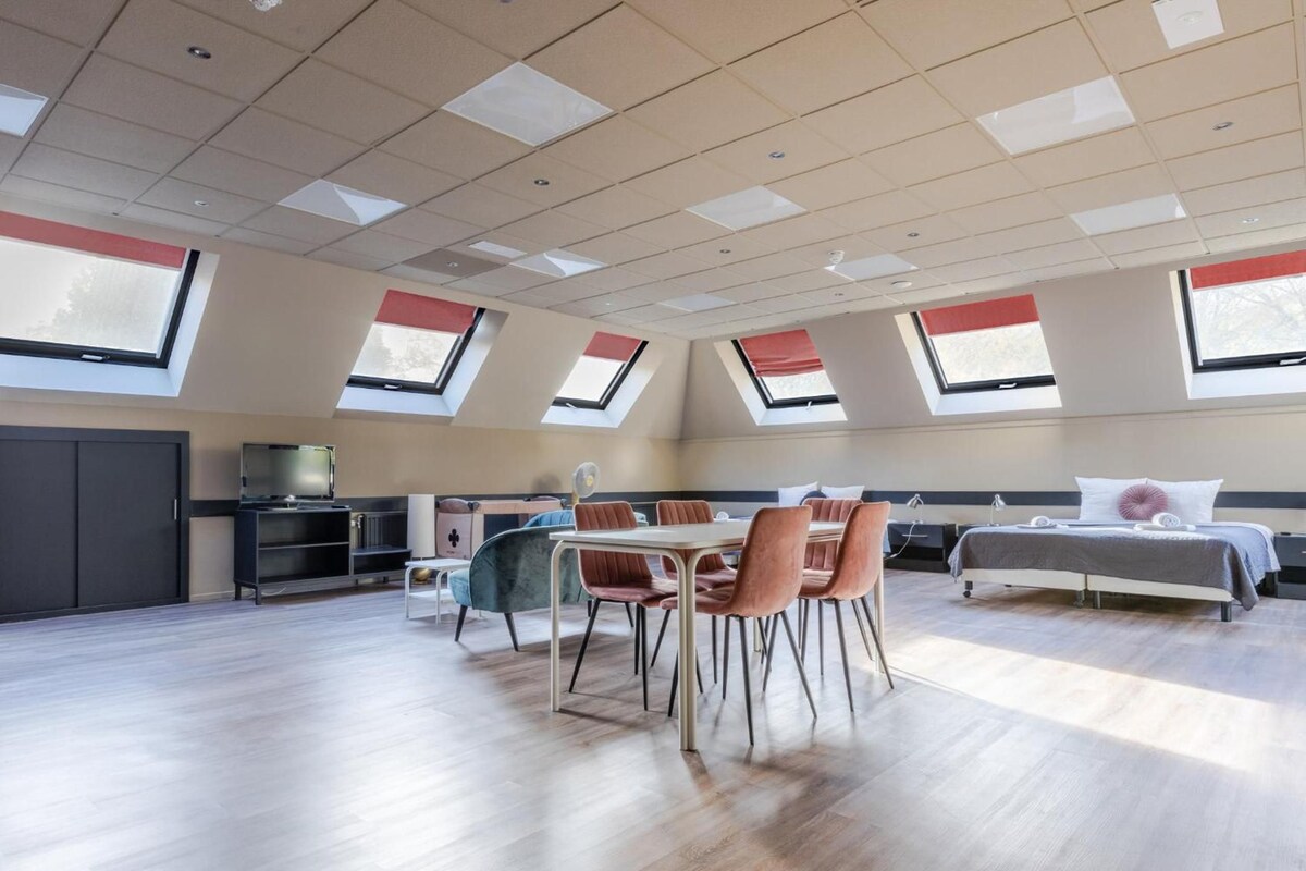 A modern interior with a dining area, kitchenette, and a bed.