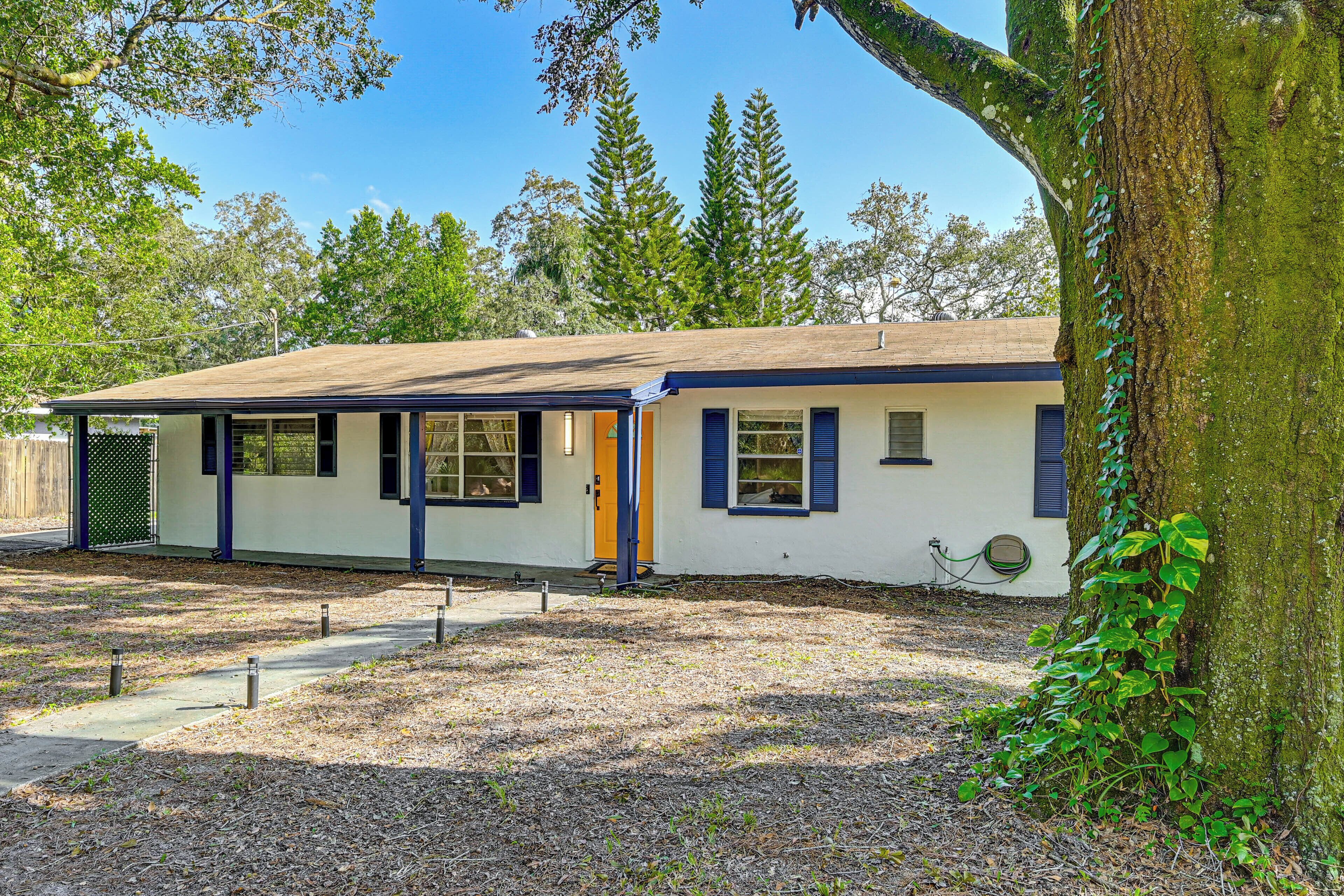 A single-story building with a flat roof, a front door, and a small porch area.