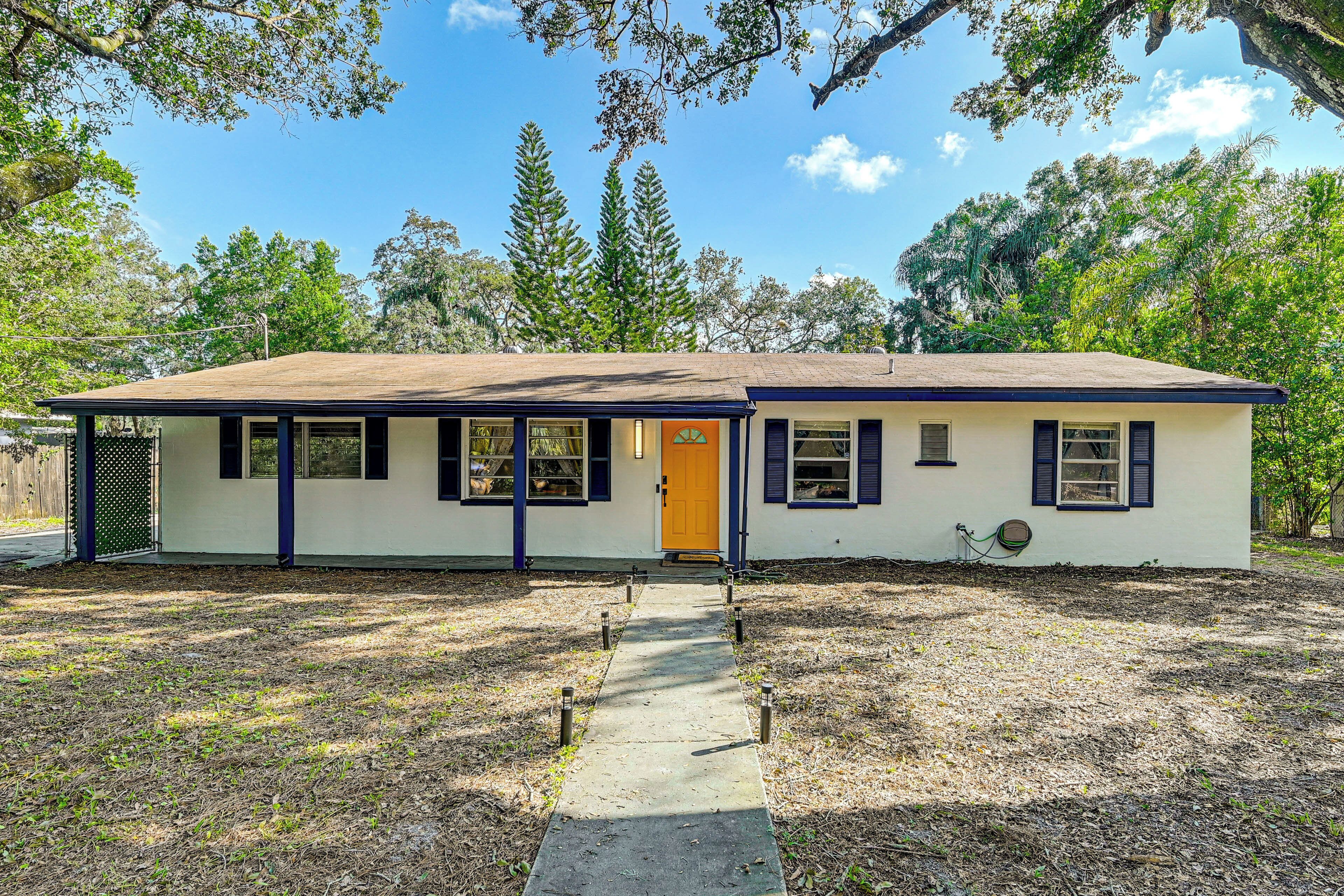 A single-story house with a front porch, a small front yard, and a clear sky.