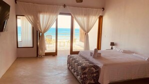 A bedroom with a bed, curtains, a view of the beach, and a chair outside. - HOP KAI Hermosa Casa de Playa en Punta Sal (Canoas de Punta Sal)