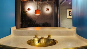 A bathroom with a large, round, gold-colored sink, three faucets, and two pendant lights. - w Elegant Loft w Amazing Deco in Poblado (Medellín)