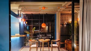 A cozy cafe with wooden furniture, orange pendant lights, and a view through a glass wall. - w Elegant Loft w Amazing Deco in Poblado (Medellín)
