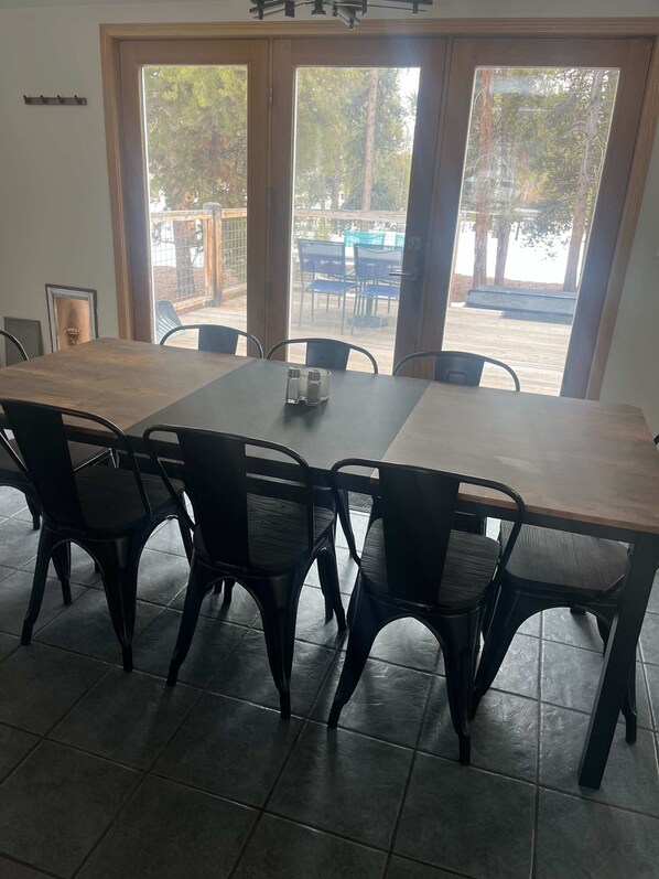 Een vergaderzaal met een grote tafel, zwarte stoelen en uitzicht op een patio door grote ramen.