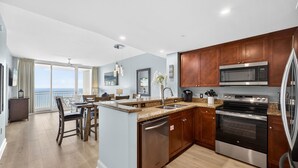 A modern kitchen with granite countertops, stainless steel appliances, and wooden cabinets.