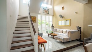 A staircase leading to a living area with a sofa, a coffee table, and a fan.