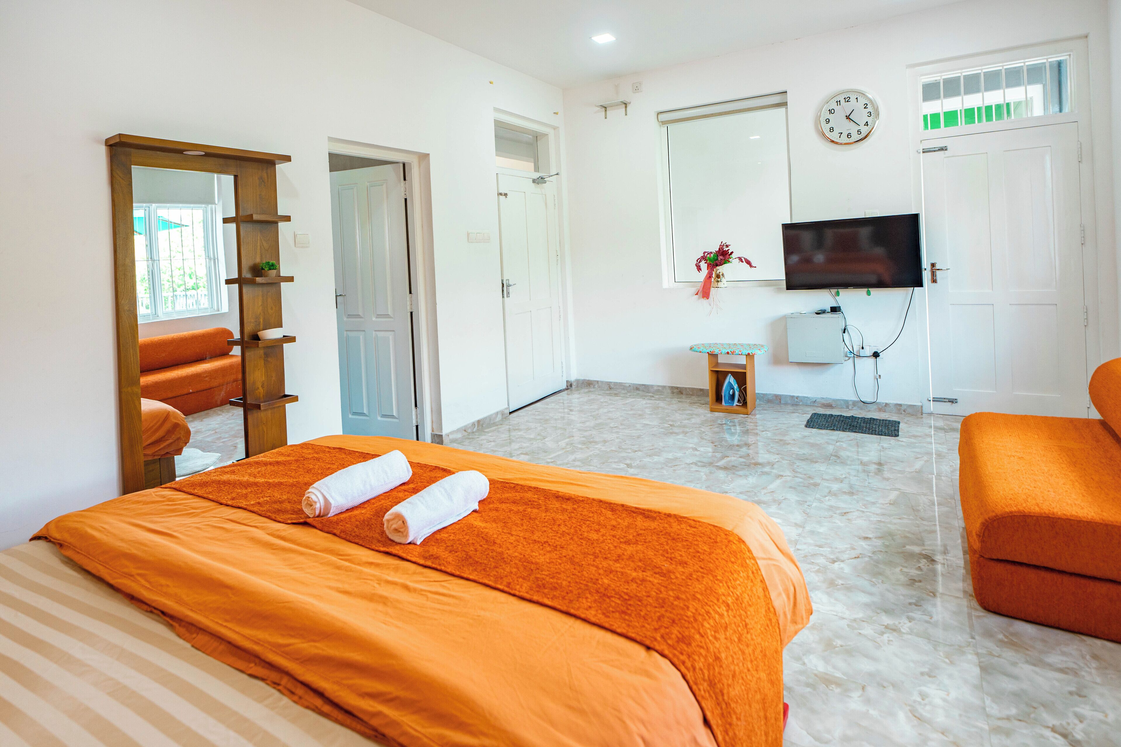 Una camera d'albergo con un letto, una TV, una scrivania e uno specchio.