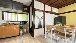 Une cuisine moderne avec des meubles en bois, un évier en acier inoxydable et une fenêtre équipée de stores.