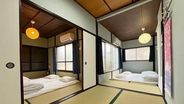 Une pièce de style japonais traditionnel, avec un sol recouvert de tatamis, un plafond bas en bois et des portes coulissantes.