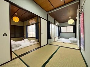 Ett traditionellt japanskt rum med tatamimattor på golvet, ett lågt trätak och skjutdörrar.