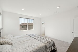 A bedroom with a bed, a window, and a door. - Spacious 3br Home With Charming Backyard 3 Bedroom Home (Folsom)