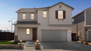A two-story house with a garage, a front door, and a small front yard with a light fixture. - Spacious 3br Home With Charming Backyard 3 Bedroom Home (Folsom)