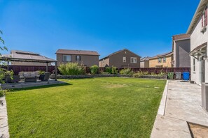 A residential backyard with a well-maintained lawn, outdoor furniture, and a patio area. - Spacious 3br Home With Charming Backyard 3 Bedroom Home (Folsom)