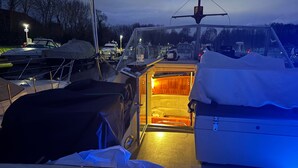 A boat interior with a cabin area, a covered deck, and a small open space in front. - Riverside Boat Retreat on the River Thames (Windsor)