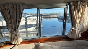 A cabin with a large window overlooking a marina. - Riverside Boat Retreat on the River Thames (Windsor)